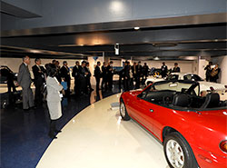 歴代の名車などが並ぶ展示室を見学する参加者