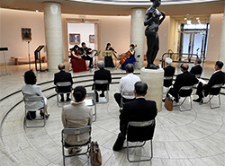 美術館のホールで弦楽四重奏の調べに聴き入る参加者