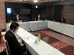 ウェブ併用で開かれた委員会で猪倉氏（左奥）の卓話を聴く会場出席者